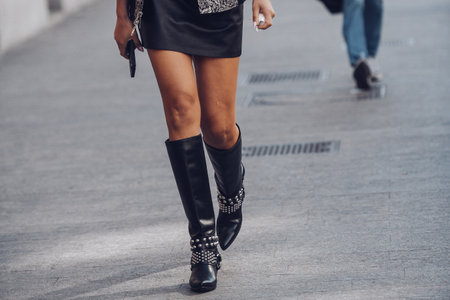 Milan, Italy - February 25, 2022: Female wearing black leather skirt and black boots white silver ornaments.のeditorial素材