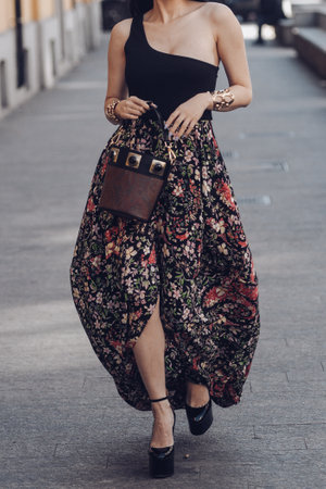 Milan, Italy - February 25, 2022: Woman wearing ornamental brown skirt and brown handbag.のeditorial素材