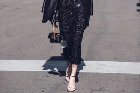 Milan, Italy - February 26, 2022: Female wearing a black glitter dress, black purse and elegant shoes.のeditorial素材