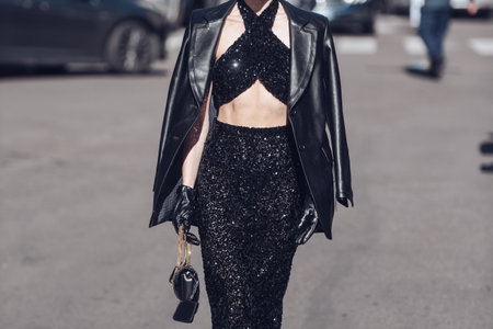 Milan, Italy - February 26, 2022: Female wearing a black glitter dress, black purse and elegant shoes.のeditorial素材