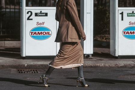 Milan, Italy - February 24, 2022: crop female in brown long dress jacket gray tights and high heeled sandals.のeditorial素材