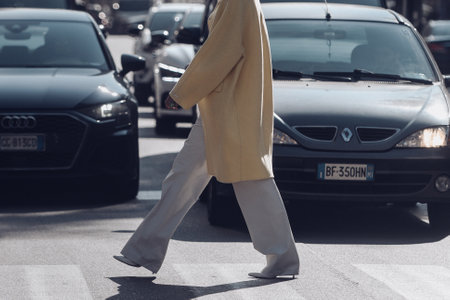 Milan, Italy - February 25, 2022: Side view of crop anonymous female in casual clothes walking.のeditorial素材