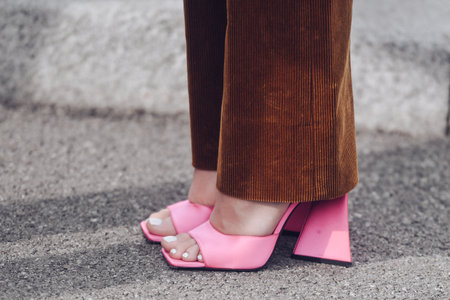 Milan, Italy - February 24, 2022: Woman in brown corduroy pants and pink high heeled sandals.のeditorial素材