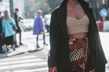 Milan, Italy - February 25, 2022: Women in beige top and black jacket walking along crosswalkのeditorial素材