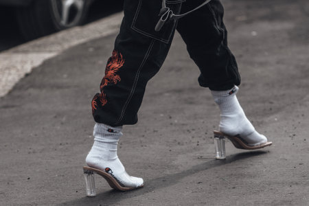 Milan, Italy - February 24, 2022: Woman in jeans with socks and mule heels.
