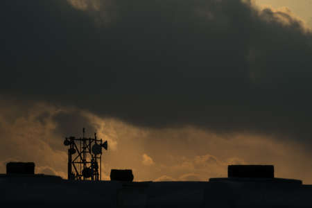 Sun rising behind dark clouds in rainy dayの写真素材