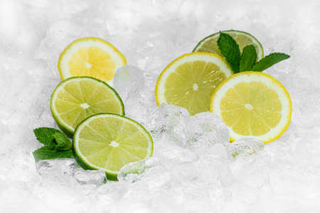 Lemon, Green Lemon and mint with crushed ice / ices cubes. Lemon ring. Ice background. Healty 2020.
