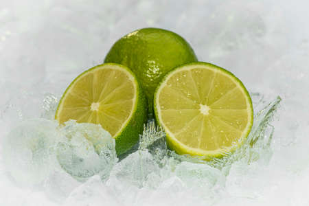 Green Lemon with crushed ice / ices cubes. Lemon ring. Ice background.