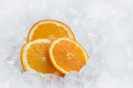 Fresh orange in ice cubes background with copy space. Healthy 2020. Healthy food. Health 2020