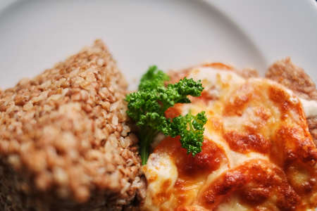 Buckwheat porridge and fried eggs in the plate close-up