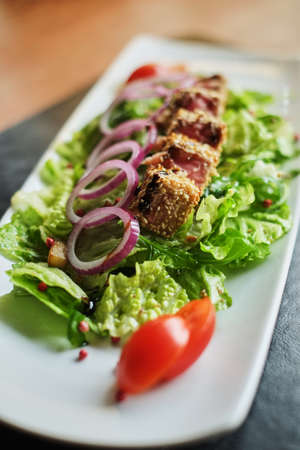 grilled salmon coated in sesame salad with bulgur and vegetables side viewの写真素材