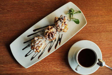 Choux cream on a narrow white plate top view wooden table backgroundの写真素材
