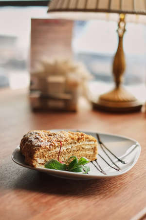 a piece of poured honey cake with chocolate topping on a plateの写真素材