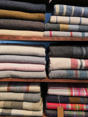 Bouquet of warm knitted pastel colors of various fabric patterns in a stack on white. Autumn winter...