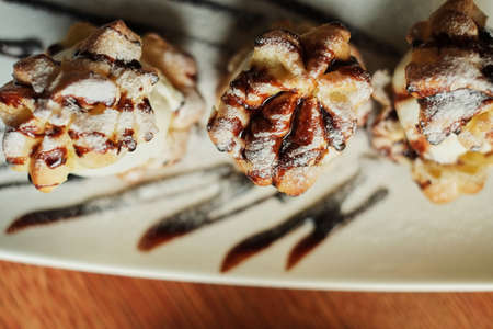 Choux cream on a narrow white plate side view wooden table backgroundの写真素材