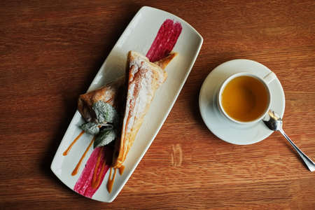 Delicious and sweet blueberry cheesecake on white plate served with whipped cream on wood table in top view with copy space. Homemade bakery for cafe and restaurant or birthday cake.の写真素材