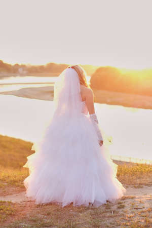 beautiful bride on the background of water Sunsetの写真素材