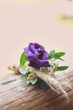 Gentle groom's boutonniere purple lies on a wooden light backgroundの写真素材