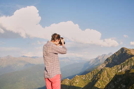 guy in the mountains taking pictures of the sunset