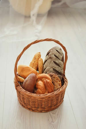 Fresh bread in a basket on a light background