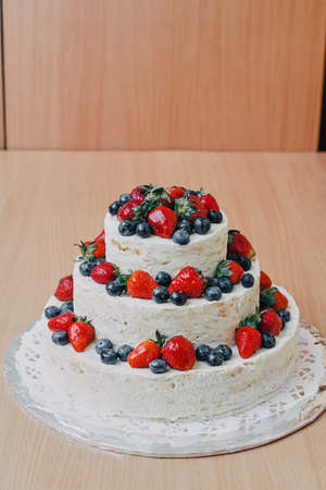 white wedding cake decorated with cherries, strawberriesの写真素材