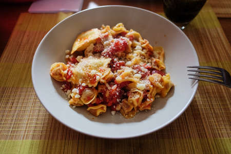 Italian cuisine. Pasta with olive oil, garlic, basil and tomatoes and tomato soup.の写真素材