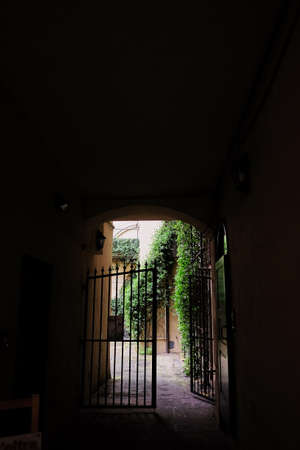 view of the gate in the courtyard through the dark arch tunnel