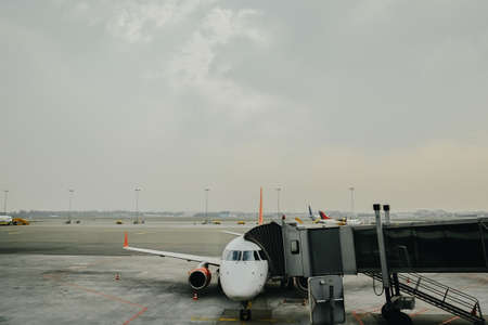 Parked aircraft on an airport through the gate window.の写真素材