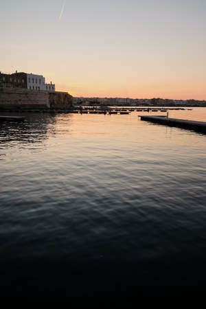 small city under lonely mountain in cozy sea bay shore line in south Mediterranean district of Earth and twilight evening darkness time after sunsetの写真素材
