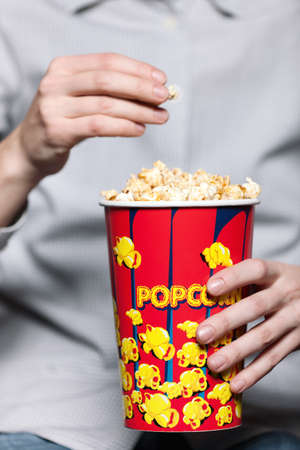 A man eating popcorn in the movie theaterの写真素材