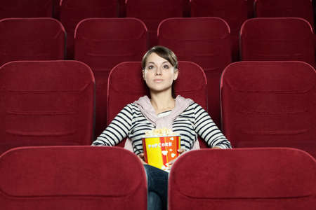 Young woman with a snack food waiting for a friend at the cinema