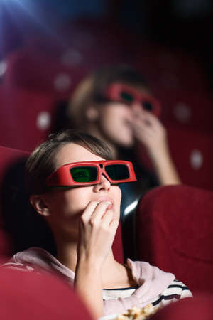 Young woman in 3D movie with popcornの写真素材