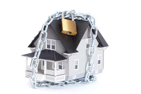Real estate concept - chain with lock around the home architectural model, isolatedの写真素材