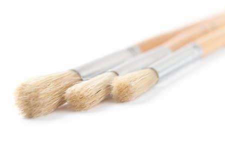 Three bright brushes are lying close to each other on white background, isolated