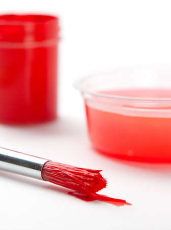 Set of brushes stained with red paint near the ink containerの写真素材