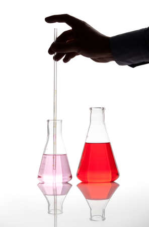 Two Erlenmeyer glass flasks with red colored chemical reagent, isolatedの写真素材