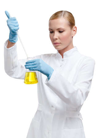 Chemist pours something to the yellow liquid in the flask, isolated on white Chemist pours something to the yellow liquid in the flask, isolated on white