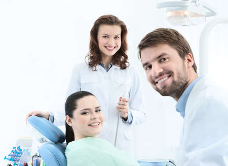 Dentist, his assistant and the patient are preparing to treat carious teethの写真素材