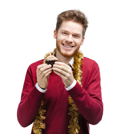 Smiley man with tinsel holds small cake, isolated on whiteの写真素材