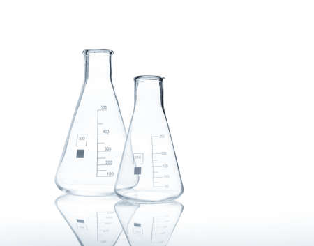 Two empty conical Erlenmeyer flasks with reflection on the surface of the table, isolatedの写真素材