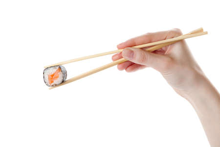 Hand holds the sushi with chopsticks, isolated on whiteの写真素材