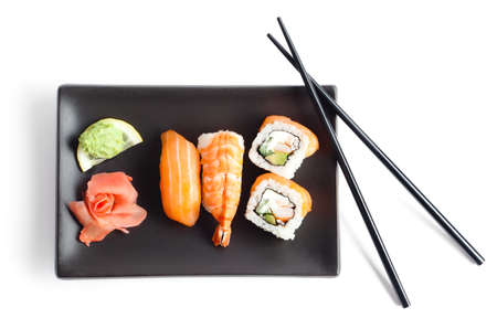 Black plate with sushi and chopsticks, isolatedの写真素材