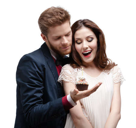 Man astonishes his wonderful girlfriend with birthday cake, isolated on whiteの写真素材