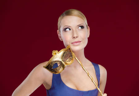 Pretty girl with masquerade masque, isolated on purpleの写真素材