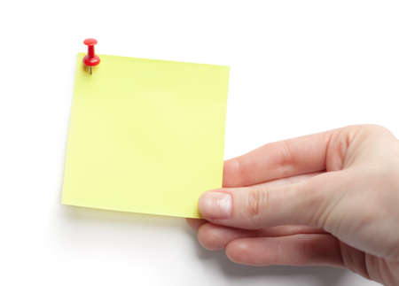 Hand with yellow sticky note on white background