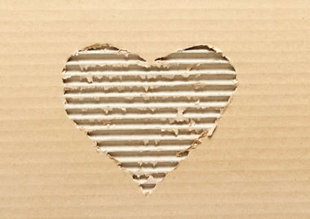 Ripped heart shaped corrugated cardboard, brown backgroundの写真素材