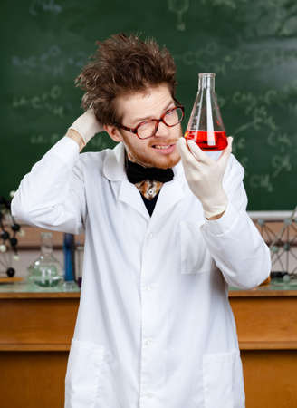 Mad professor holds Erlenmeyer flask with red liquidの写真素材