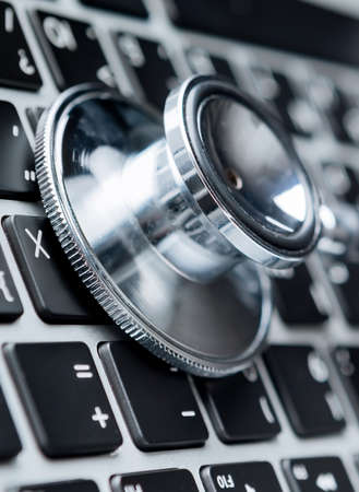 Close up of stethoscope on laptop keyboard. Healthcare concept