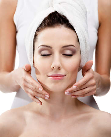 Makeup artist applies cosmetics on the woman's face with eyes closed at beauty salonの写真素材