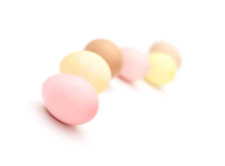 Winding line of multicolored hen's eggs, isolated on white